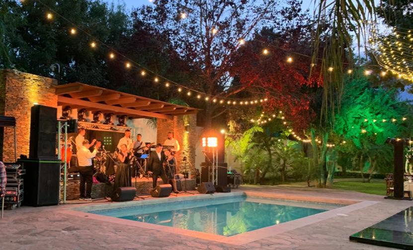Banda en vivo junto a la alberca al anochecer