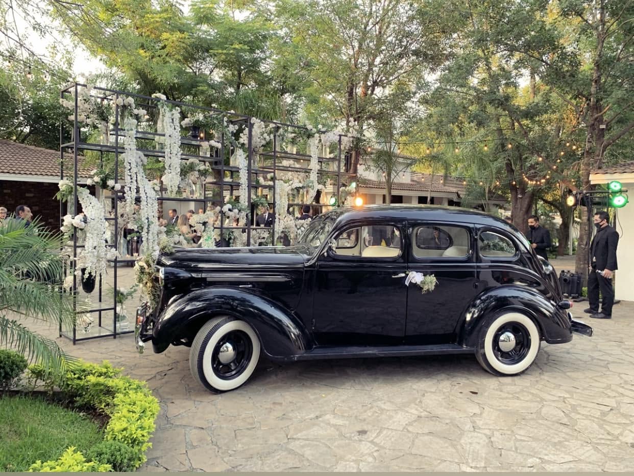 Auto clásico en la entrada decorada con flores